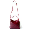 Cartera de cuero burdeos de silueta sobria con asas regulables, modelo Paula marca _BRAVA, vista completa.